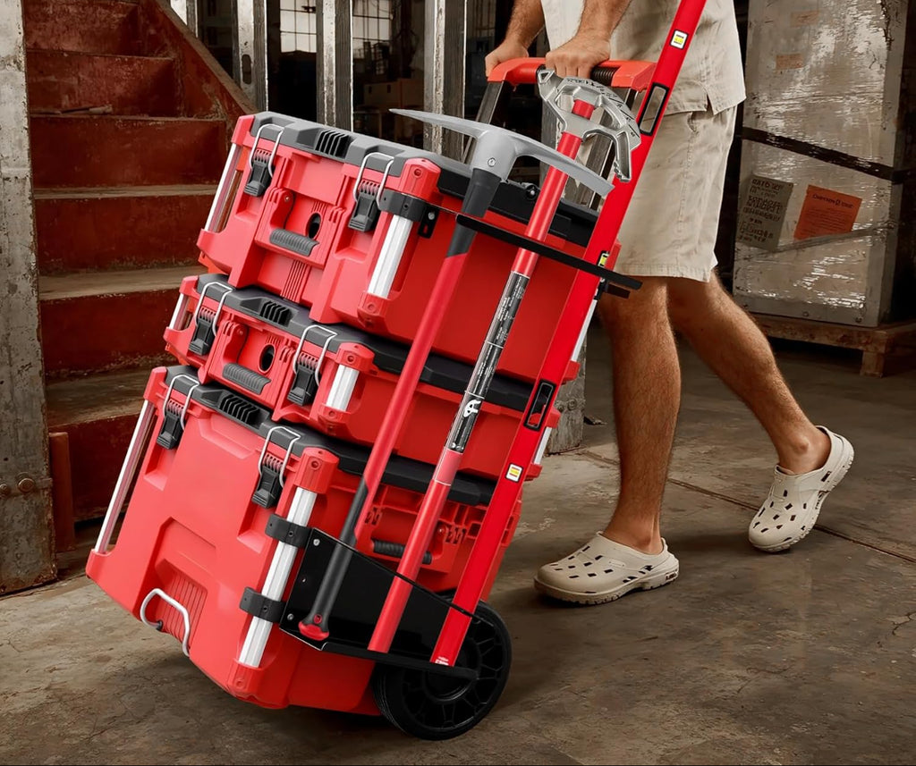 Red tool storage cart with tools on wheels being pulled by a person in an industrial setting.