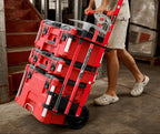 Red tool storage cart with tools on wheels being pulled by a person in an industrial setting.